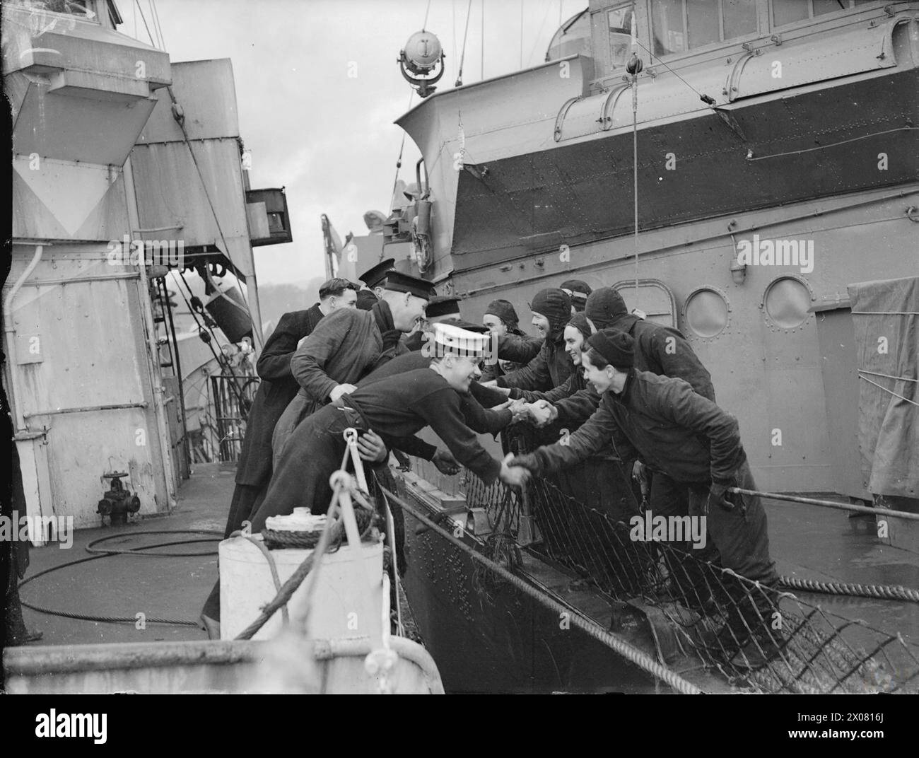 AMERICANS IN BRITAIN, 1942 - 1945 - The Londonderry Naval base : les marins britanniques et américains se saluent de leurs destroyers qui sont sécurisés à côté lorsque les premiers navires de guerre américains escortant un convoi à travers l'Atlantique sont arrivés à Londonderry, janvier-février 1942 Royal Navy, United States Navy Banque D'Images