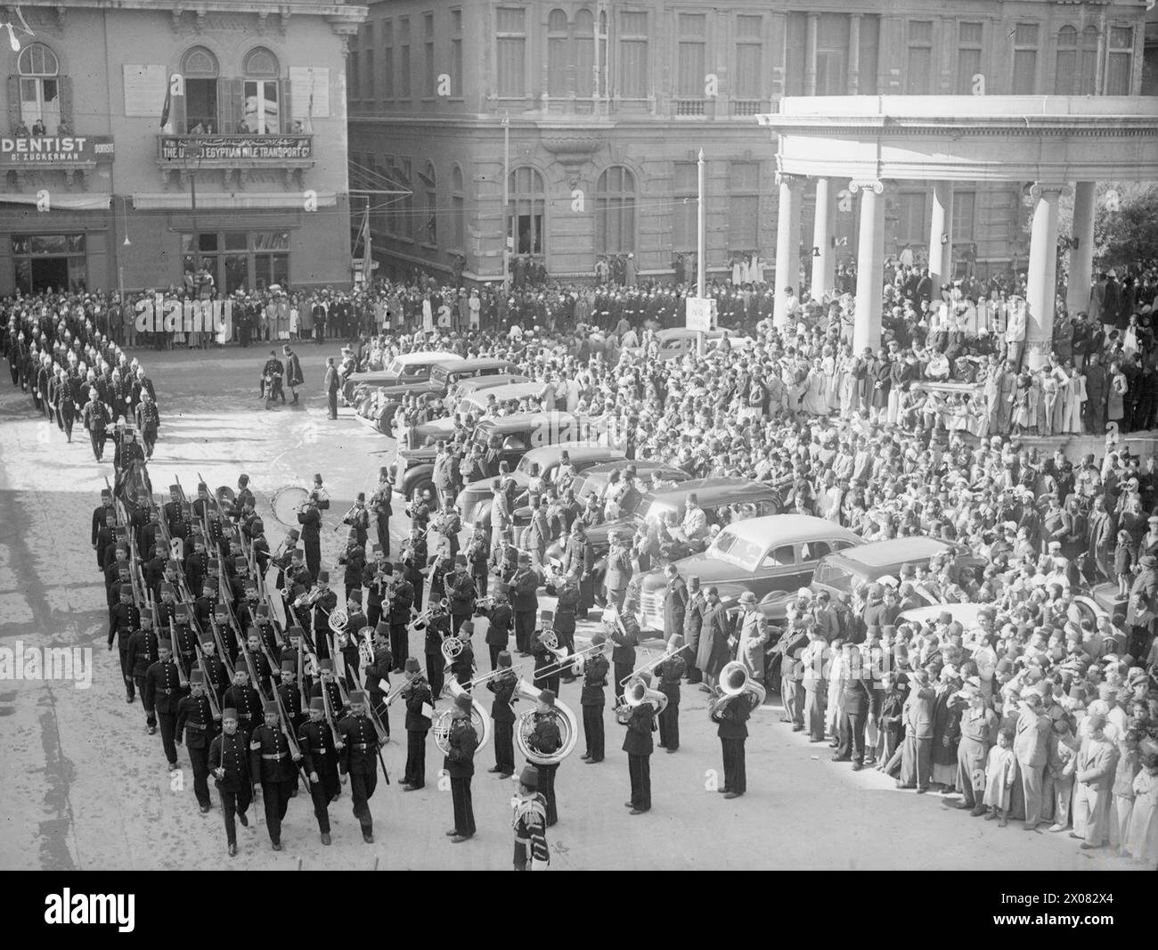 Des officiers de la marine britannique assistent à la grande marche passée des forces militaires et de défense civile égyptiennes à Alexandrie, en Égypte, en février 1945 pour honorer l'anniversaire du roi Farouk. Le gouverneur Abdel Khalek Hassoune a reçu le salut. Banque D'Images