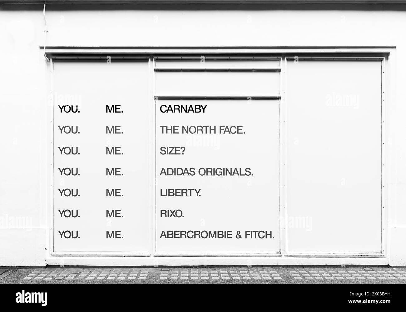 Publicité, sur un magasin fermé, pour des magasins dans Carnaby Street, Soho, Londres, Angleterre. Banque D'Images