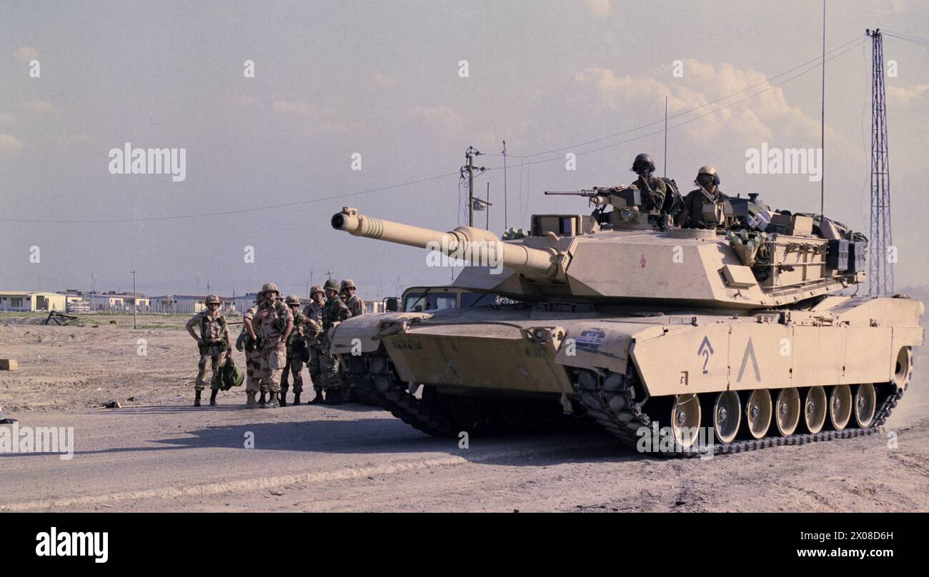 27 mars 1991 un réservoir d'Abrams de l'armée américaine passe par un groupe de soldats à la périphérie de Safwan, dans le sud de l'Irak. Banque D'Images