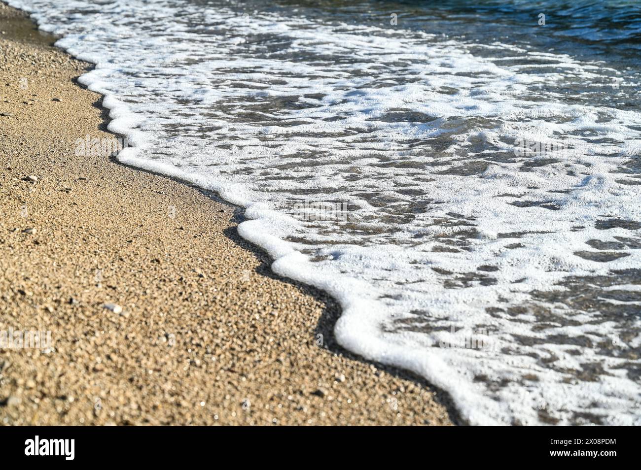 Vagues de mer sur la plage de sable au coucher du soleil. Banque D'Images