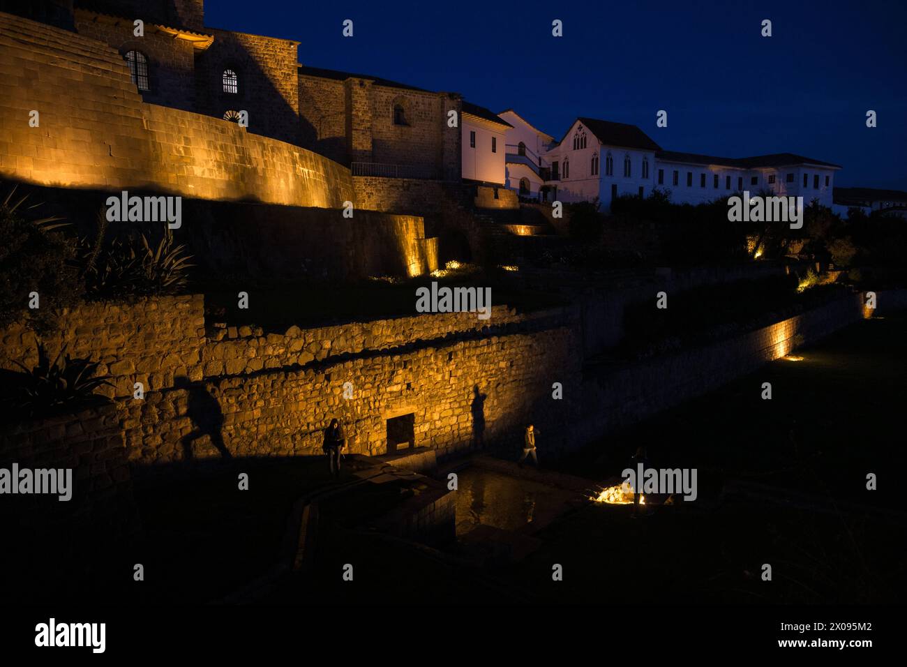 Coricancha et le couvent de Santo Domingo à Cusco Pérou est illuminé dans la soirée comme les touristes et les touristes sont silhouettés Banque D'Images