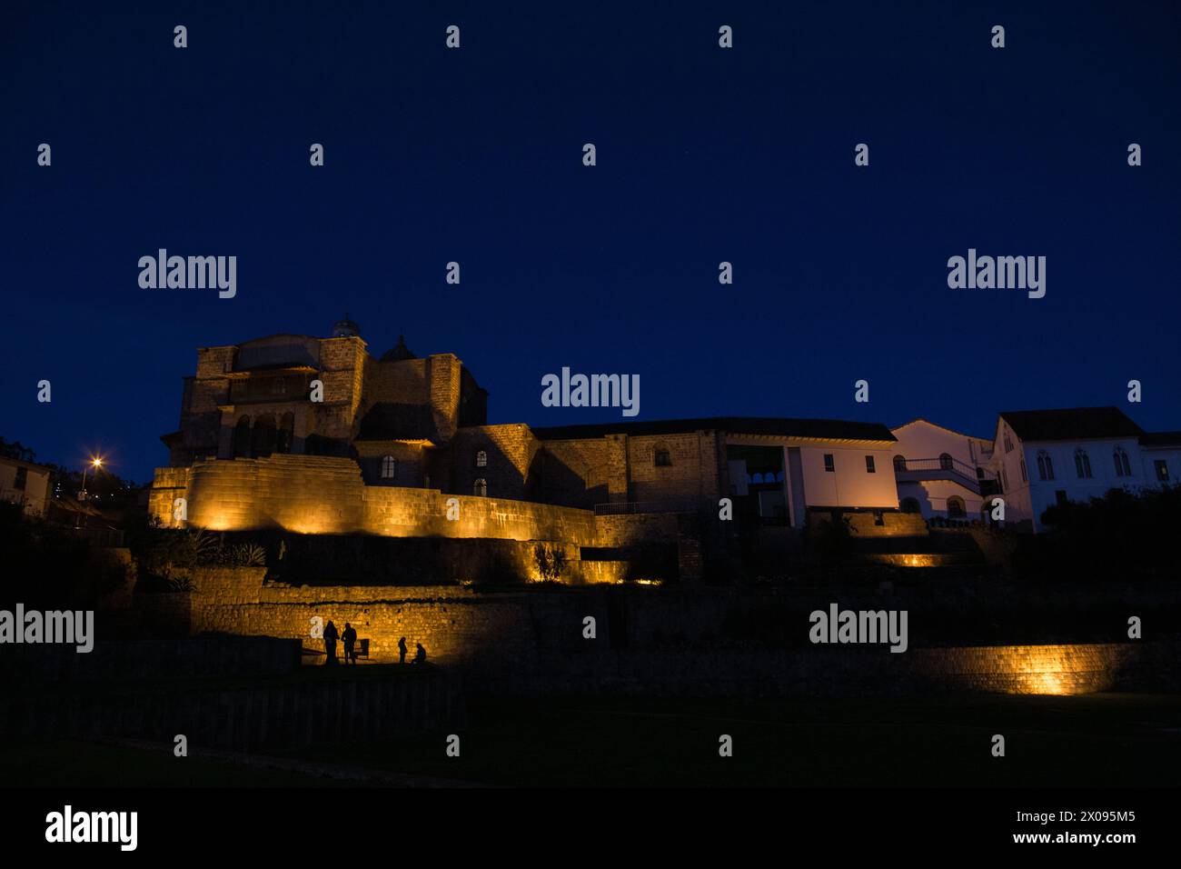 Coricancha et le couvent de Santo Domingo à Cusco Pérou est illuminé dans la soirée comme les touristes et les touristes sont silhouettés Banque D'Images