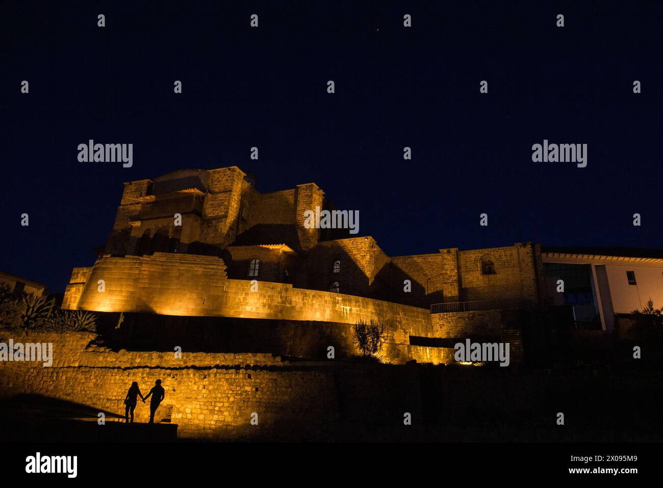Coricancha et le couvent de Santo Domingo à Cusco Pérou est illuminé dans la soirée comme les touristes et les touristes sont silhouettés Banque D'Images