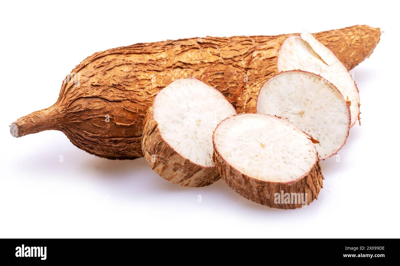 Tubercules de manioc avec feuilles et tranches de manioc isolés sur fond blanc. Banque D'Images