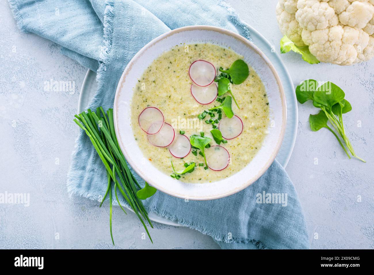 Soupe crémeuse de chou-fleur blanche avec radis et ciboulette, nourriture saine avec des herbes Banque D'Images Soupe crémeuse de chou-fleur blanche avec radis et ciboulette, nourriture saine avec des herbes Banque D'Images