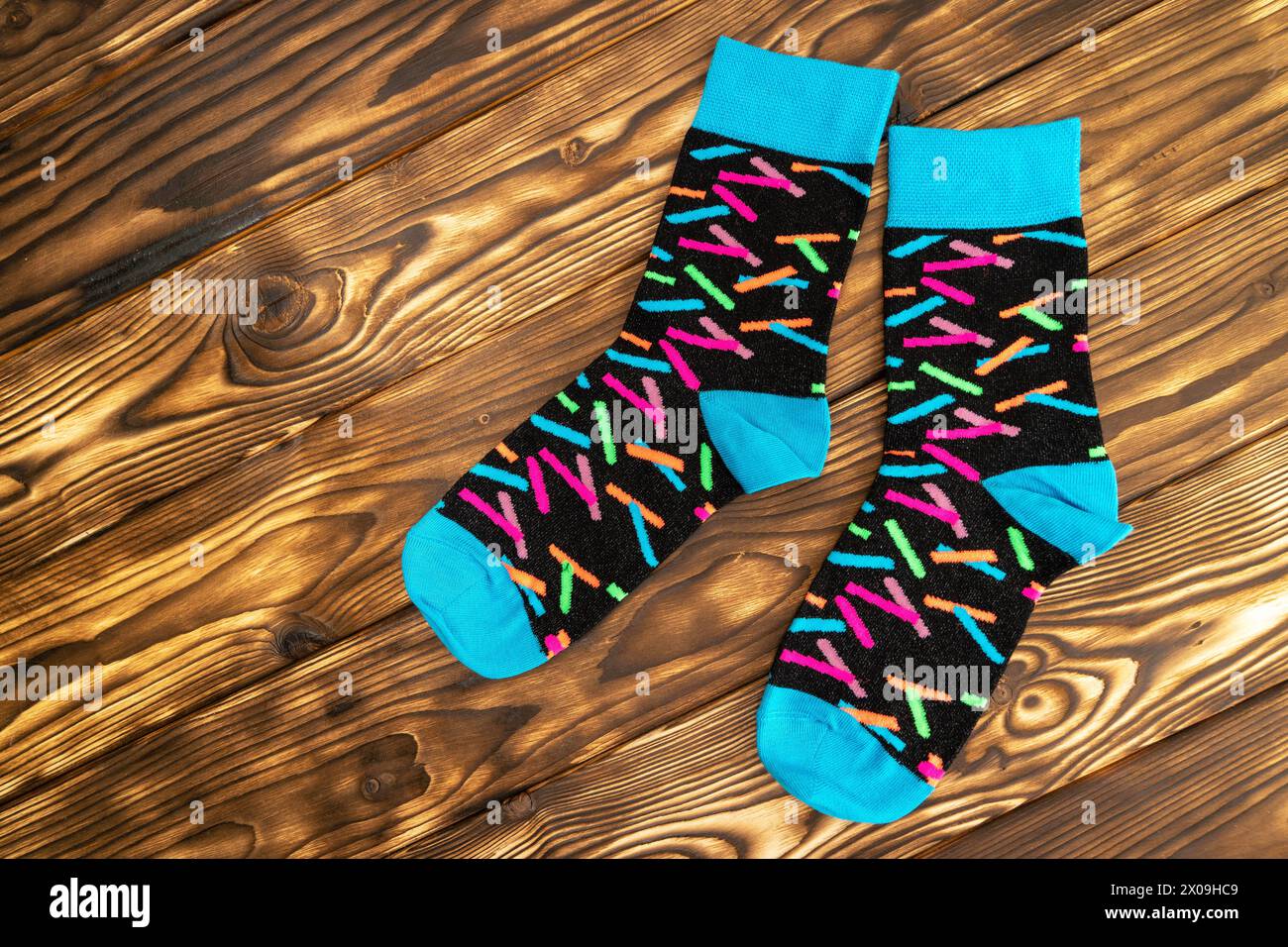 Une paire de chaussettes noires recouvertes de saupoudrages colorés, ajoutant une touche amusante et vibrante à l'essentiel de la garde-robe classique. Banque D'Images