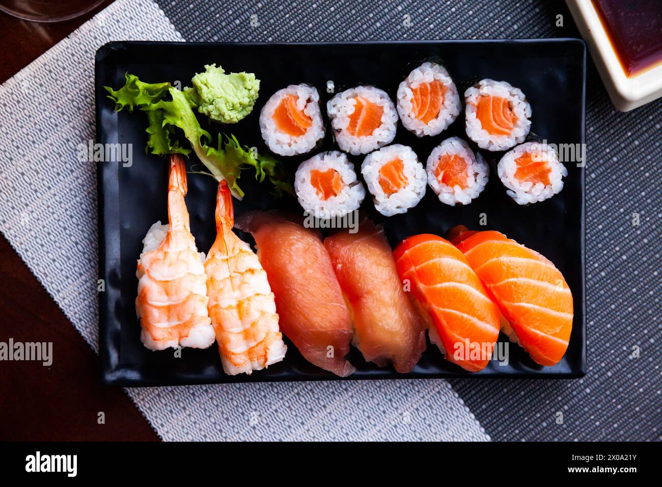 Divers sushis servis sur une assiette noire. Cuisine japonaise Banque D'Images