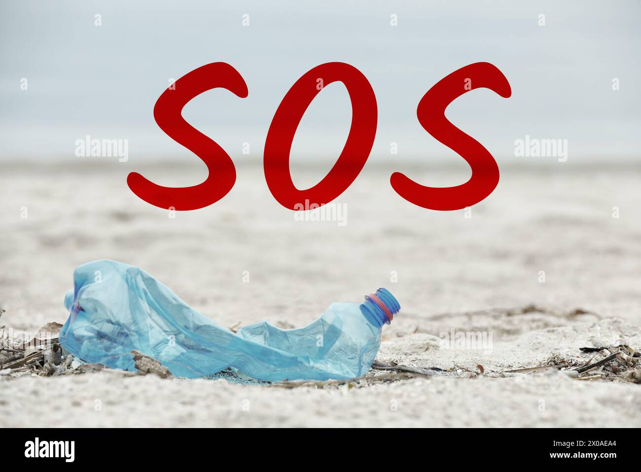 Mot SOS et bouteille en plastique utilisée sur la plage. Problème de recyclage Banque D'Images