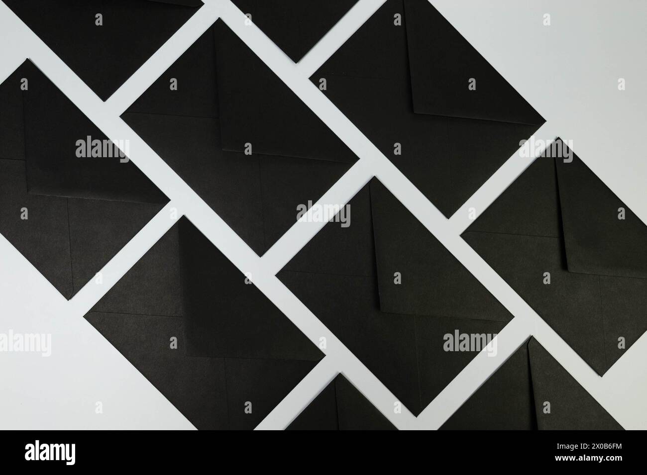 Vue de dessus des enveloppes noires sur fond gris. Post pose à plat. Copier l'espace. Banque D'Images