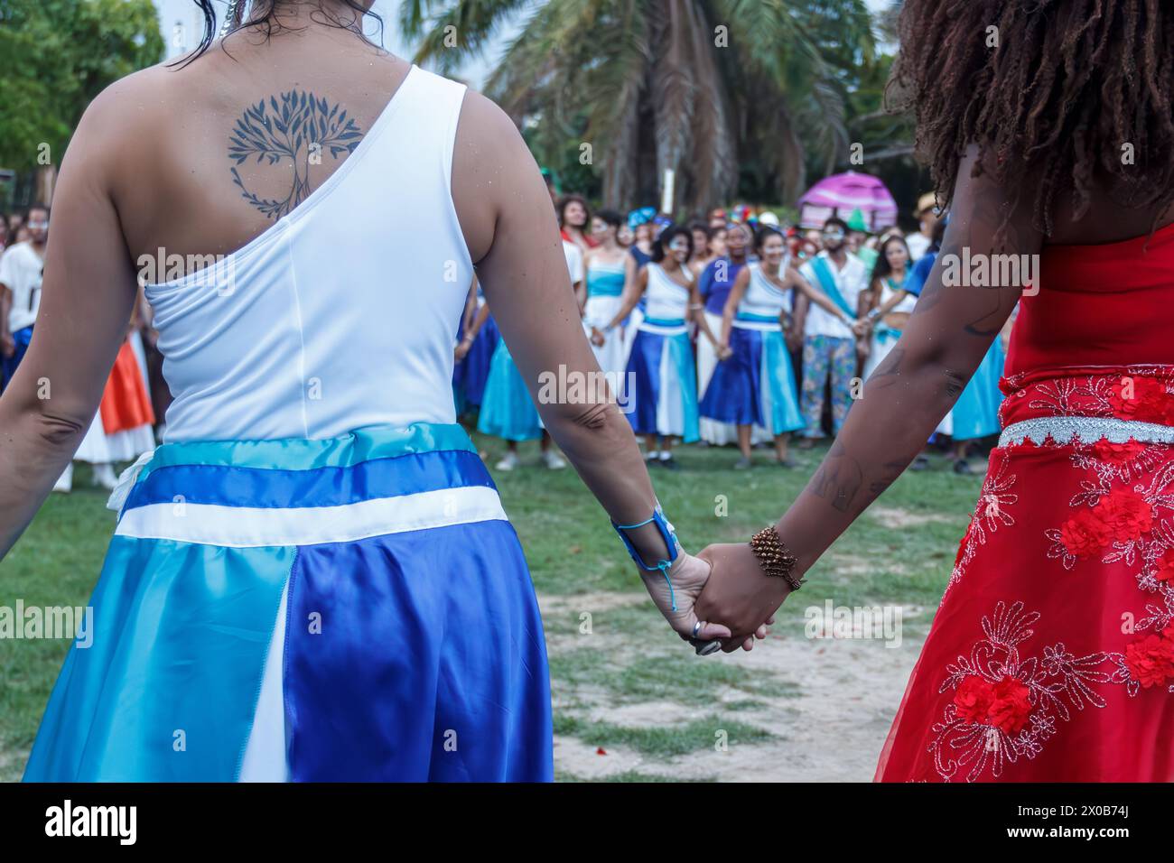 Des femmes de Maracatu, une activité artistique culturelle et religieuse brésilienne, se tenant par la main dans un geste de paix, de célébration, de respect et d’amitié Banque D'Images