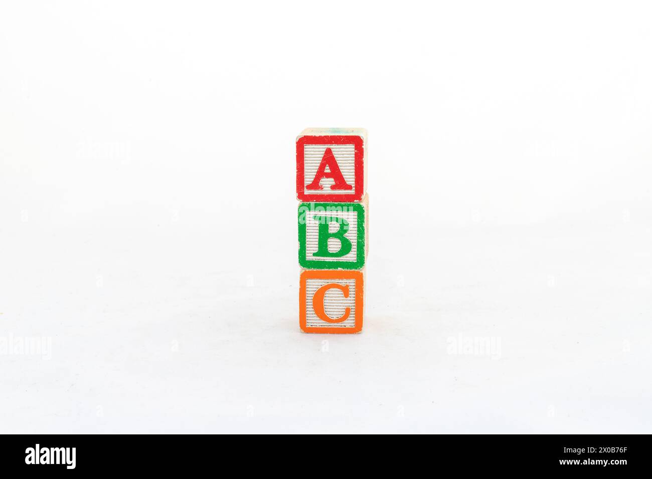 Blocs d'alphabet en bois orthographiant ABC isolé sur un fond blanc avec espace de copie. Banque D'Images