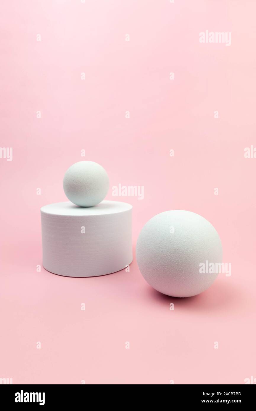 Podium rond blanc, boules blanches sur fond rose. Formes abstraites géométriques pour la présentation de produits cosmétiques. Copier l'espace. Banque D'Images