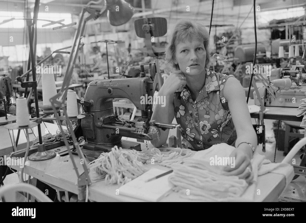 Aktuell 28-6-1973 : Trebarnsmamma på fabrikkgolvetKvinnenes kår i arbeidslivet Jofrid Jensen jobber på trikotasjefabrikken Harald Christensen A/S. I dag har fabrikken en arbeidsstokk på 70 personer, av dem 65 kvinner. Alle jobber akkord. Hun er fornøyd Med lønnen. Timelønnen til de ansatte kan på det mest ekstreme variere mellom 9 og 17 kroner timen, men det pleier ikke å ta lang tid før kvinnene arbeider i et raskt akkordtempo. Foto : ODD Ween / Aktuell / NTB ***FOTO IKKE BILDEBEHANDLET*** ce texte a été traduit automatiquement! Banque D'Images
