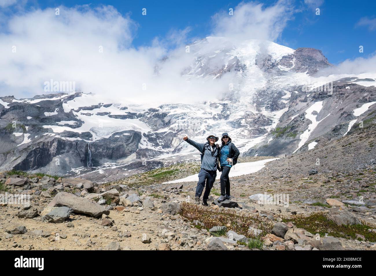 Couple posant pour des photos à Skyline Trail avec le Mont Rainier en arrière-plan. Parc national du Mont Rainier. Etat de Washington. Banque D'Images