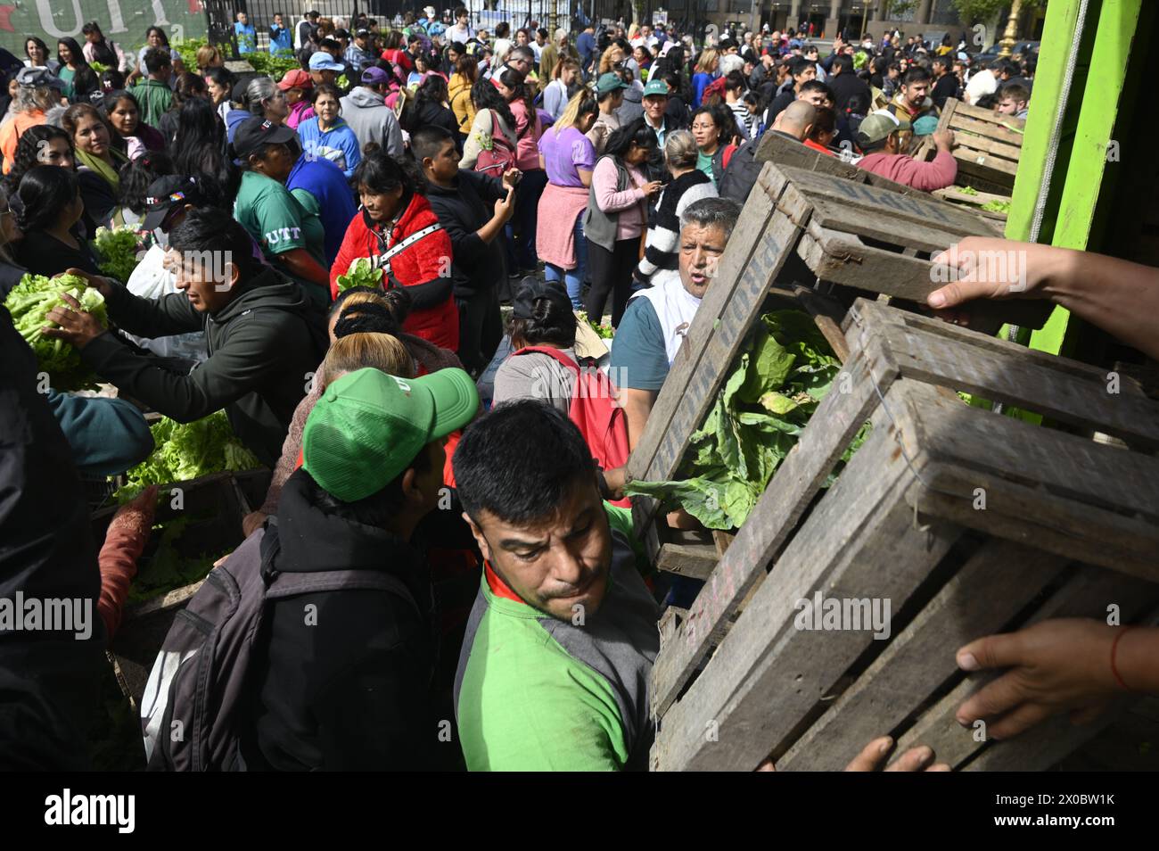 Buenos Aires, Argentine. 10 avril 2024. Un homme remet une boîte en bois de fruits et légumes à une foule devant le Congrès argentin. Des centaines de personnes se rassemblent devant le Congrès national argentin pour recevoir gratuitement divers fruits, légumes et plantes directement des producteurs agricoles de l’UTT (Union des travailleurs du Land) en raison de la crise économique que traverse le pays en avril. (Photo par Igor Wagner/SOPA images/SIPA USA) crédit : SIPA USA/Alamy Live News Banque D'Images