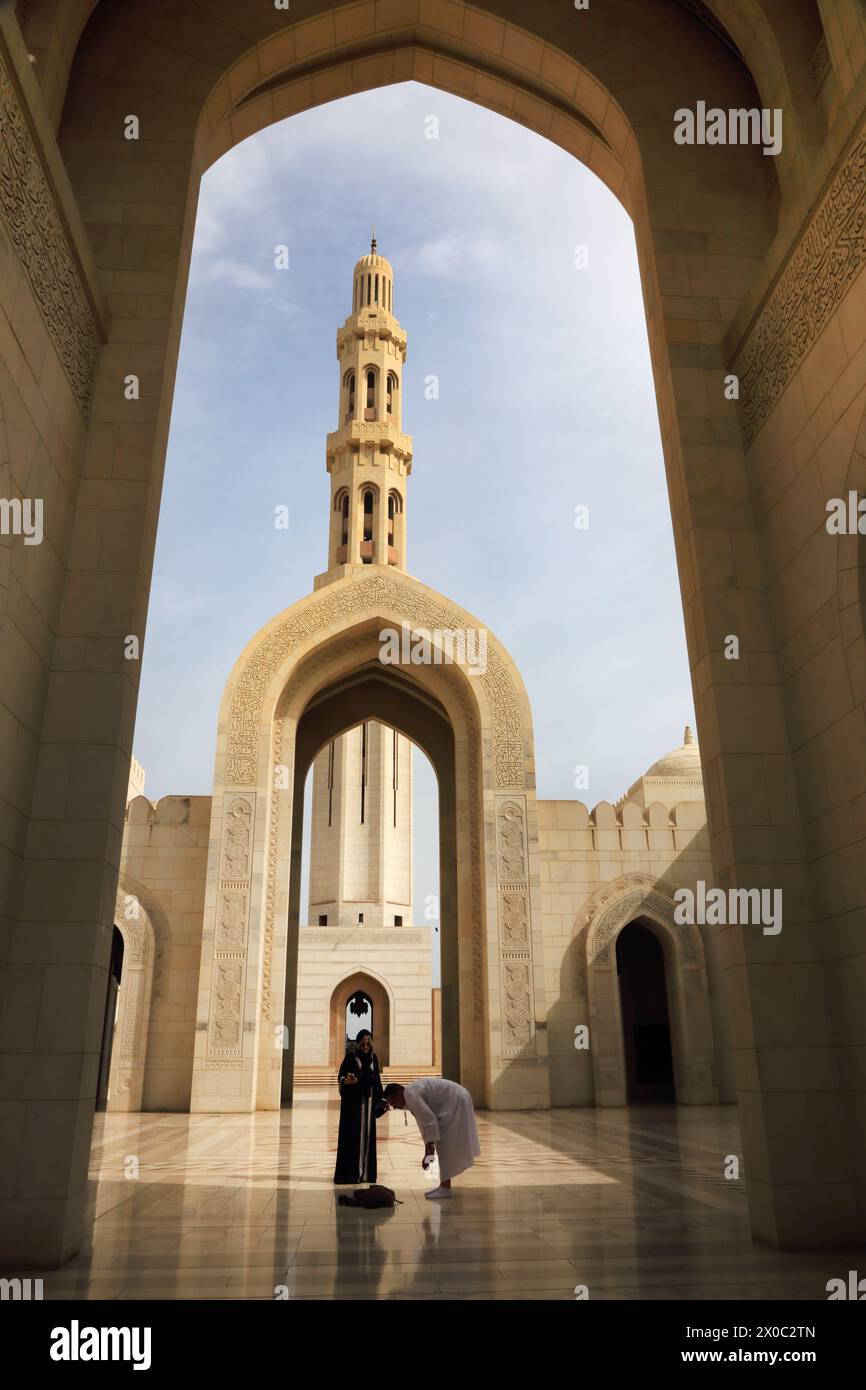 Sultan Qaboos Grand Mosquée homme et femme par Archway et Minaret Muscat Oman Banque D'Images