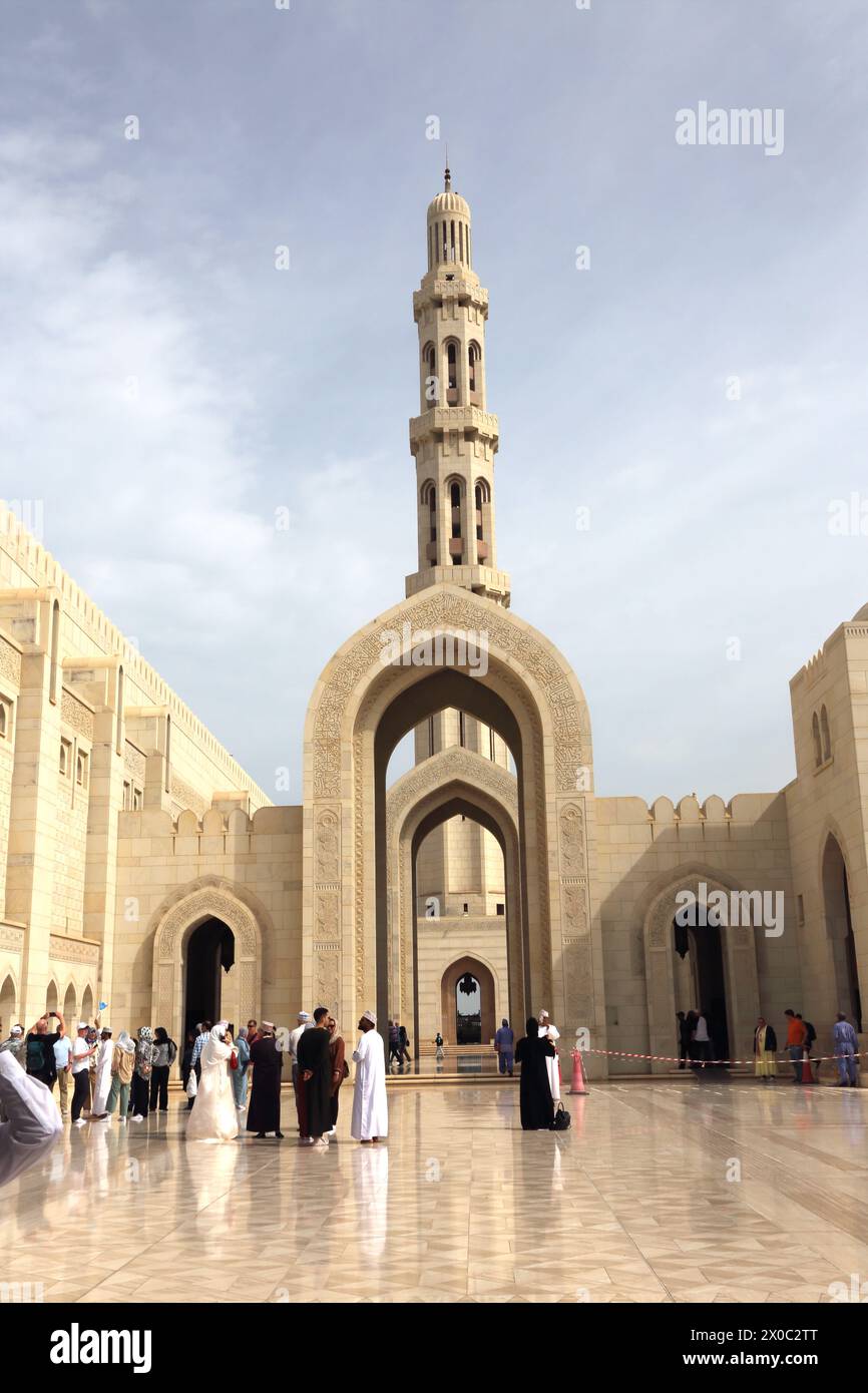 Sultan Qaboos Grande Mosquée touristes et habitants par Archway et Minaret Muscat Oman Banque D'Images