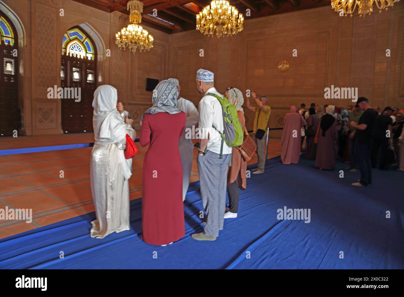 Sultan Qaboos Grande Mosquée touristes debout sur couverture bleue pour protéger le tapis de prière dans la salle de prière des femmes Muscat Oman Banque D'Images