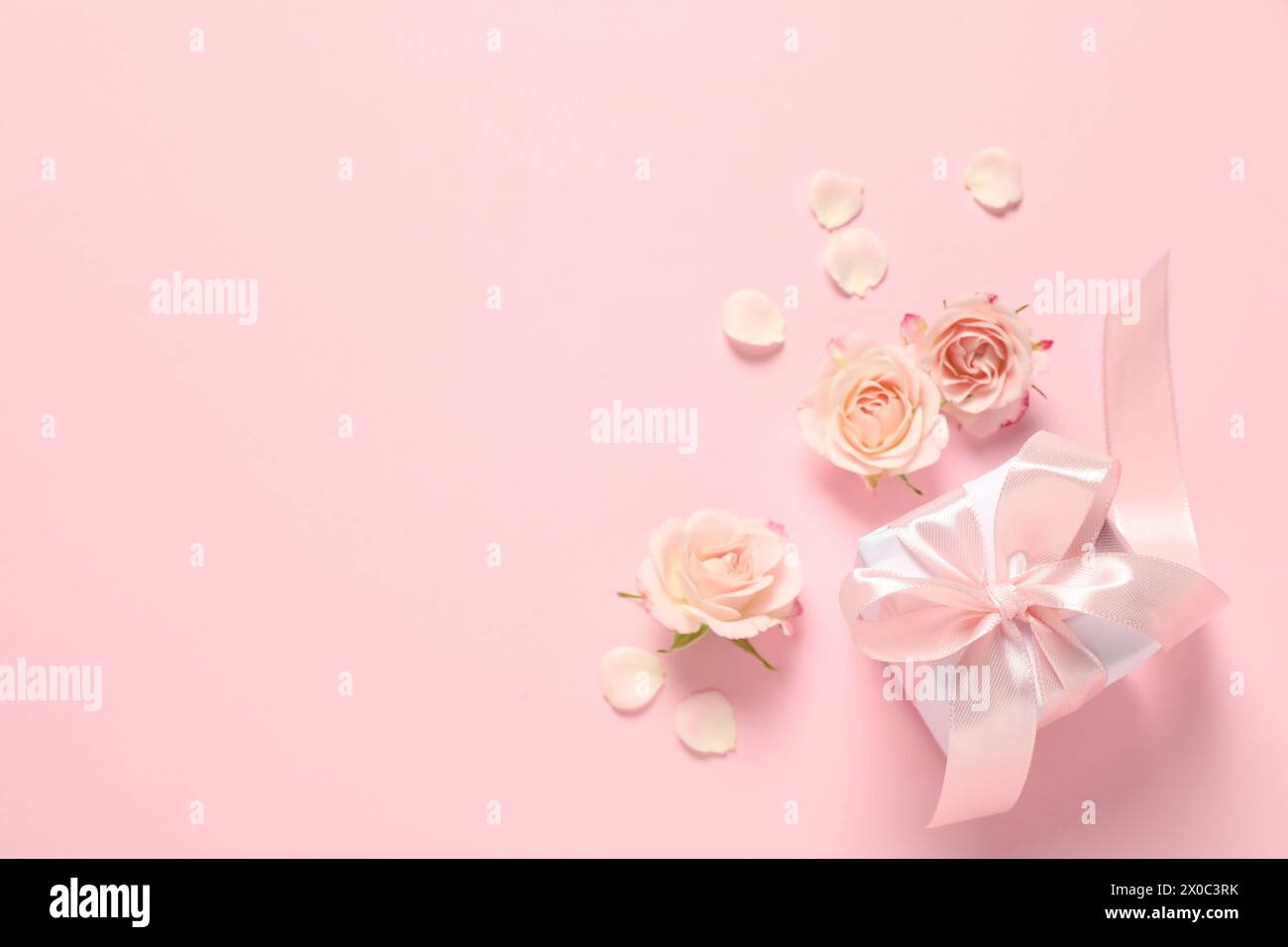 Bonne fête des mères. Belles fleurs et boîte-cadeau sur fond rose, plat. Espace pour le texte Banque D'Images