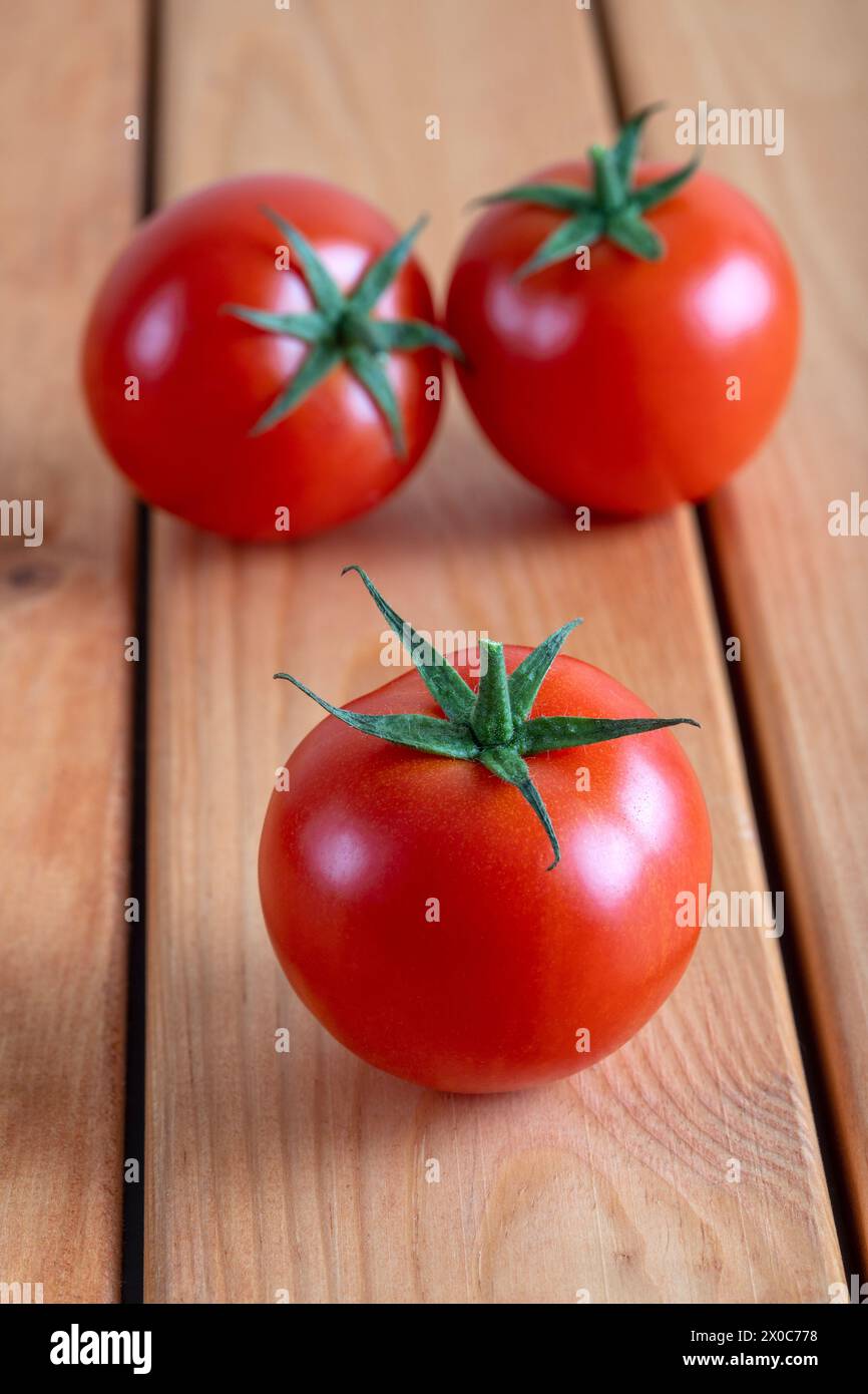 Un groupe de tomates rouges sur une table en bois Banque D'Images