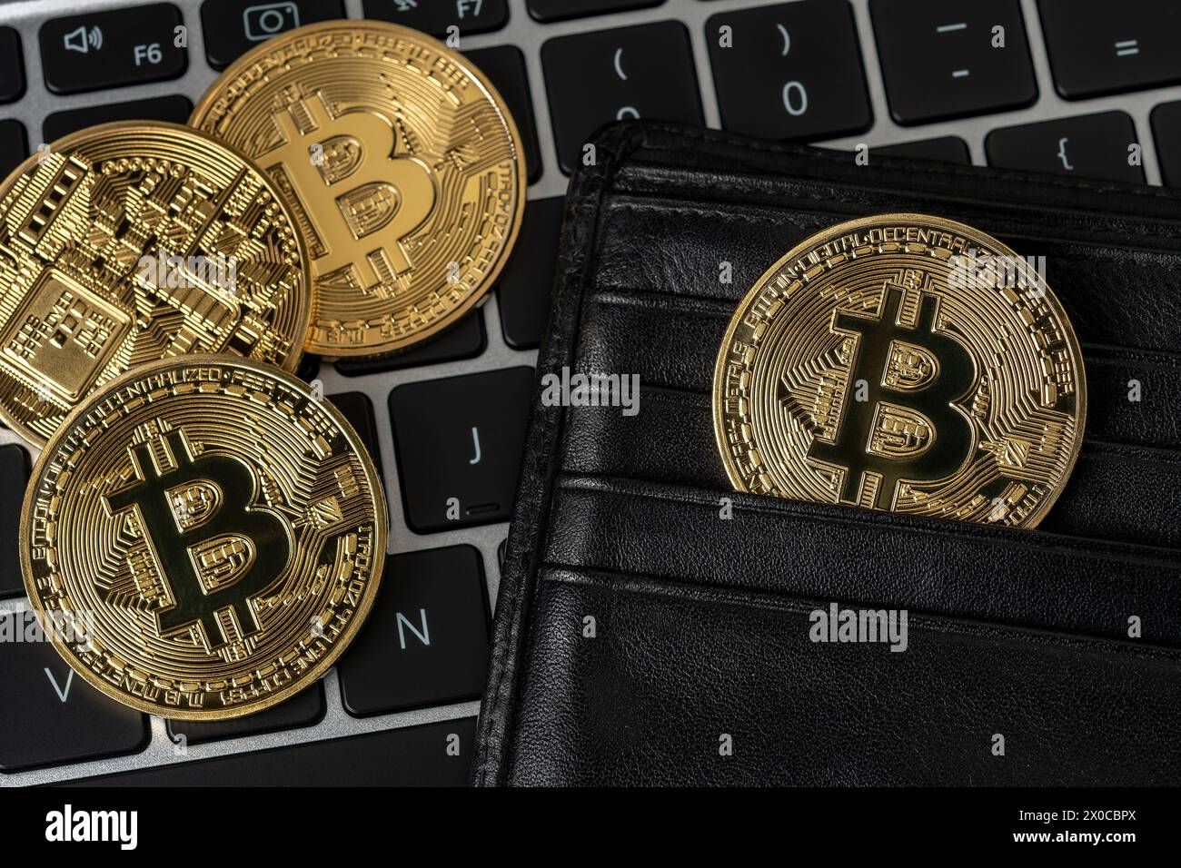 Bitcoin crypto-monnaie pièces d'or dans un portefeuille noir sur ordinateur portable. Banque D'Images