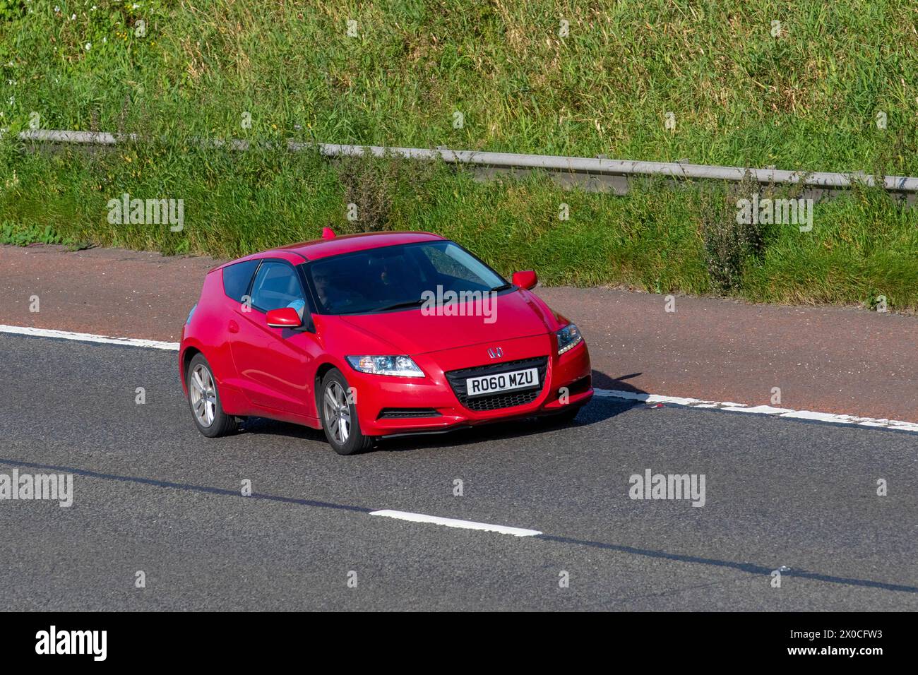 2010 Red Honda CR-Z SP i-VTEC IMA Hybrid, 1497cc, 16 soupapes VTEC voiture essence voyageant sur l'autoroute M6, Royaume-Uni Banque D'Images