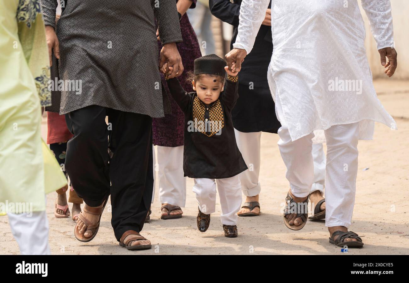 GUWAHATI, INDE - 11 AVRIL : des musulmans avec des enfants marchent vers un Eidgah pour effectuer la prière de l'Aïd Al-Fitr à Guwahati, Inde, le 11 avril 2024. Les musulmans du monde entier célèbrent la fête de l’Aïd al-Fitr, qui marque la fin du mois de jeûne du Ramadan Banque D'Images