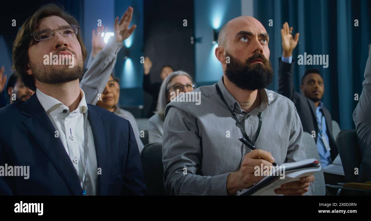 Divers représentants des médias lèvent la main et écrivent les réponses dans des cahiers du président ou d'un politicien dans la salle de conférence du bâtiment du gouvernement. Les journalistes posent des questions pendant la campagne de presse. Banque D'Images