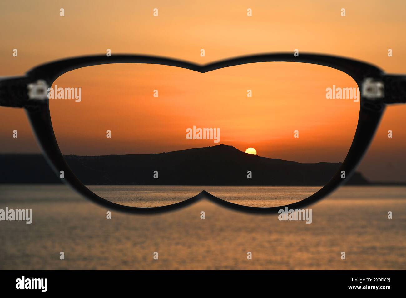 Coucher de soleil sur les montagnes et la mer vus dans la mise au point en regardant à travers une paire de lunettes avec des lentilles pour corriger la vision courte. Concept de vision. Banque D'Images