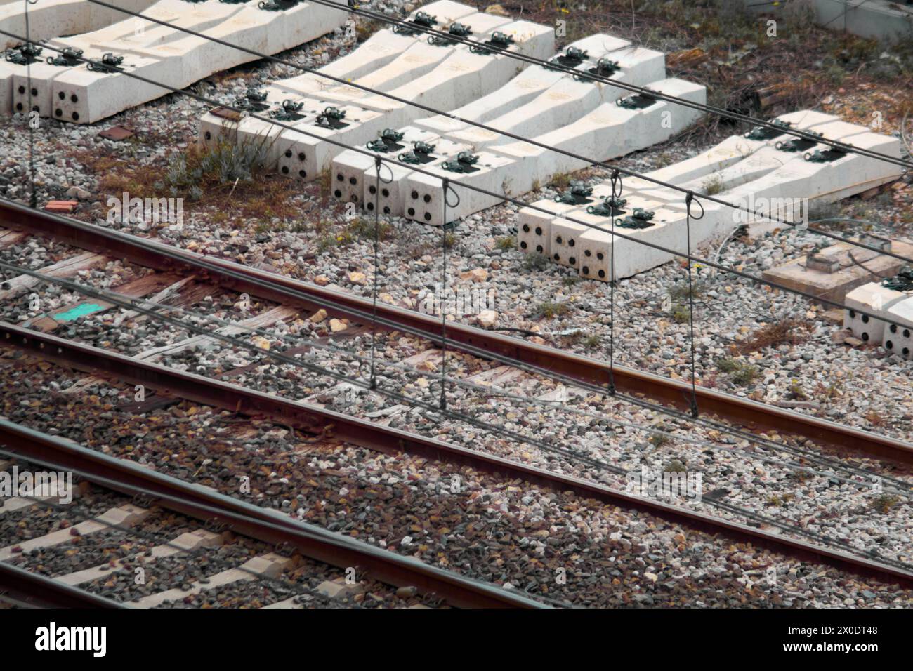 Une vue aérienne révèle des traverses de chemin de fer abandonnées et des voies rouillées, peignant une image d'infrastructures oubliées lentement récupérées par la nature Banque D'Images