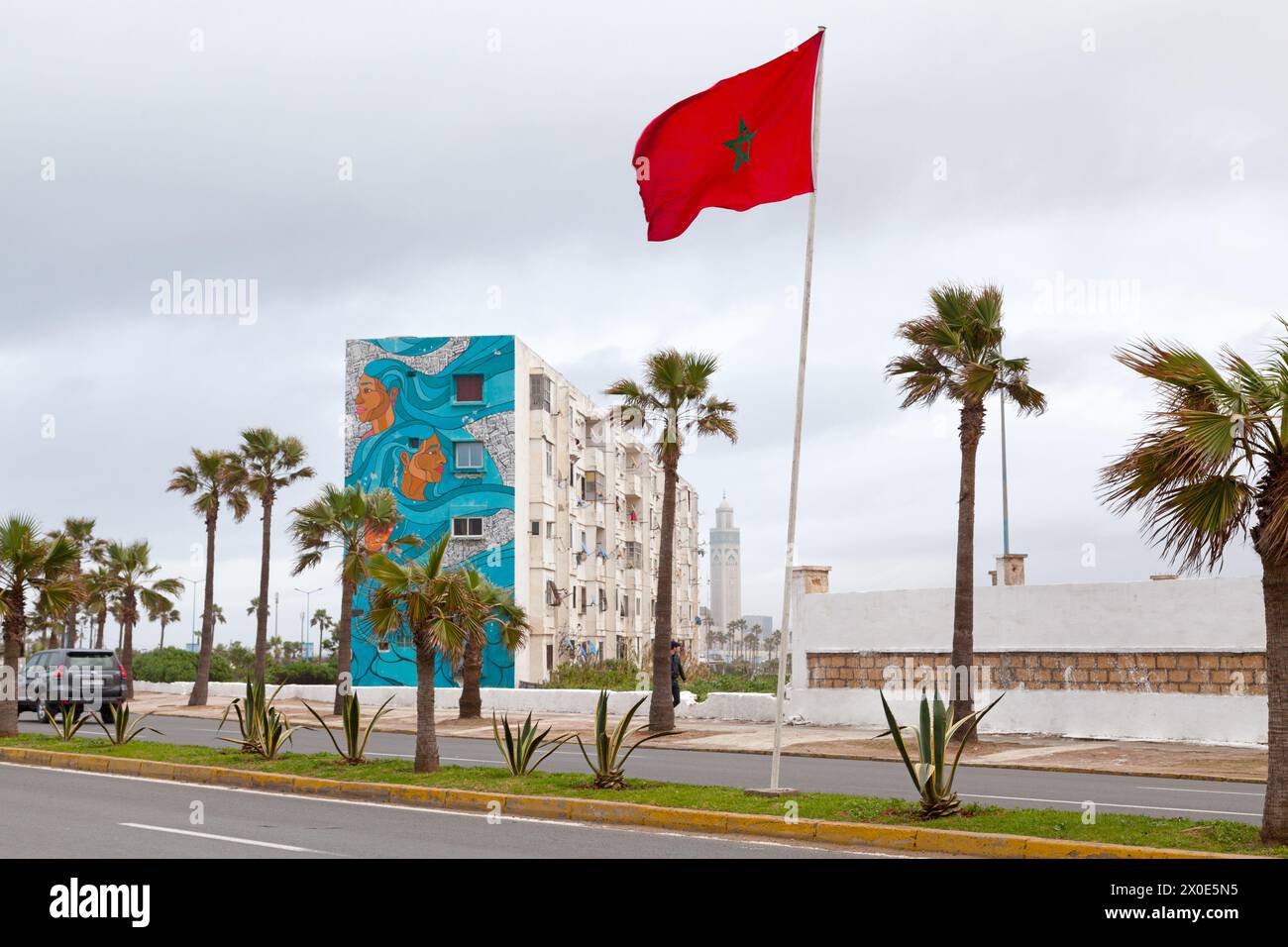 Casablanca, Maroc - 20 janvier 2019 : drapeau marocain agitant devant un bâtiment dans le quartier d'El Hank décoré d'une fresque de l'artiste de rue 'Sam Kirk'. Banque D'Images