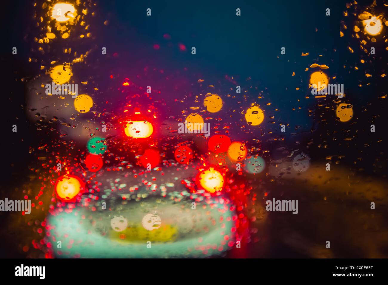 Vue à travers un pare-brise de voiture la nuit dans la circulation et la pluie battante Banque D'Images