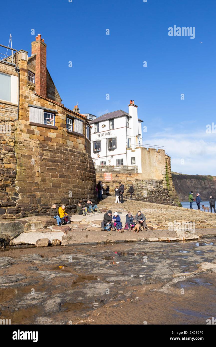 Les gens apprécient le soleil d'hiver à Robin Hood's Bay, North Yorkshire, Royaume-Uni Banque D'Images