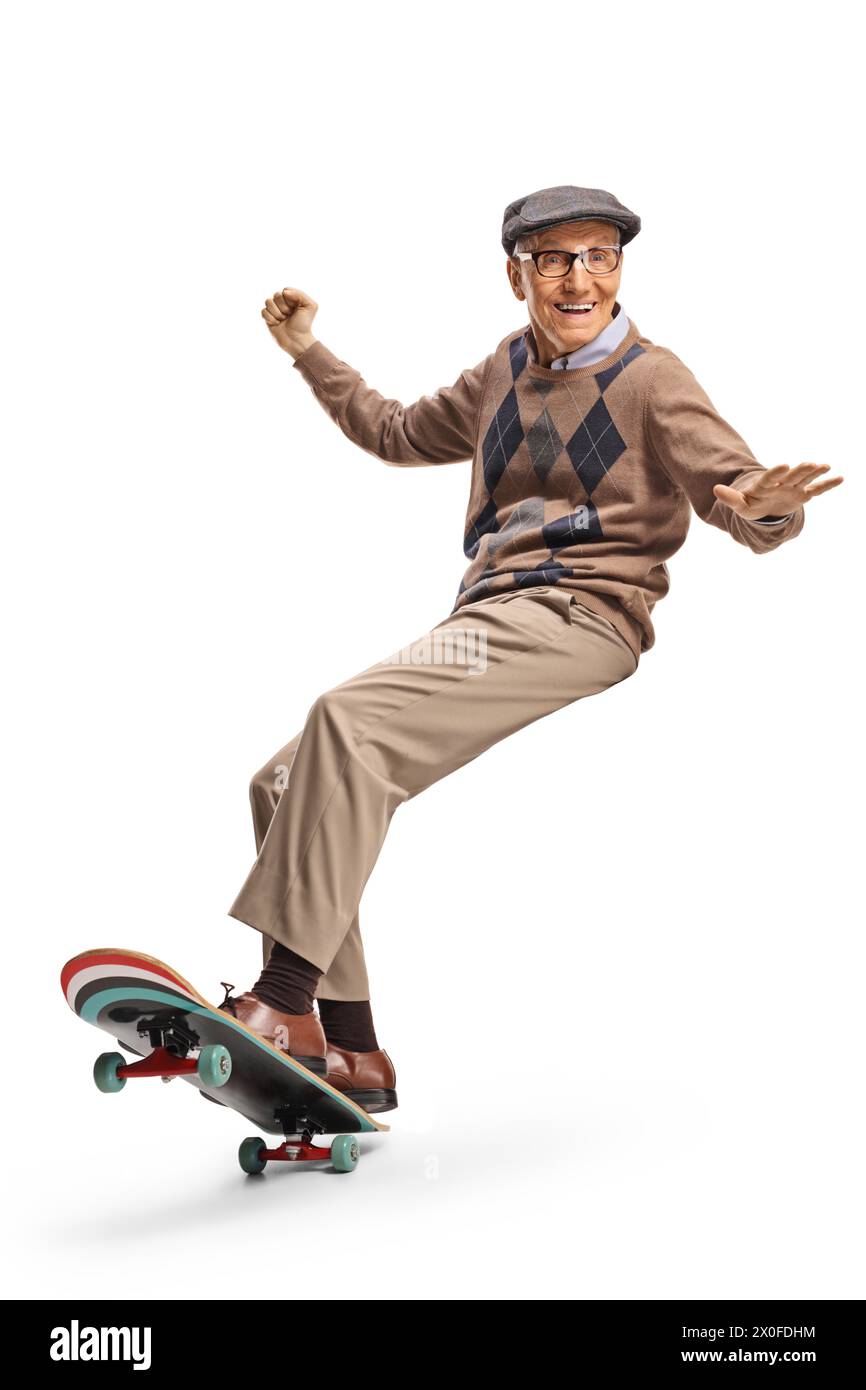 Homme âgé heureux chevauchant une planche à roulettes et souriant isolé sur fond blanc Banque D'Images
