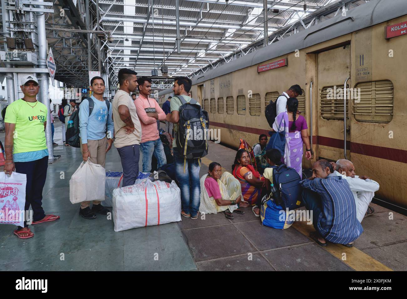 Voyageurs ferroviaires sur un quai au Chhatrapati Shivaji Maharaj Terminus à Mumbai, en Inde, attendant de monter à bord de leur train, le Koyna Express à Kolhapur Banque D'Images