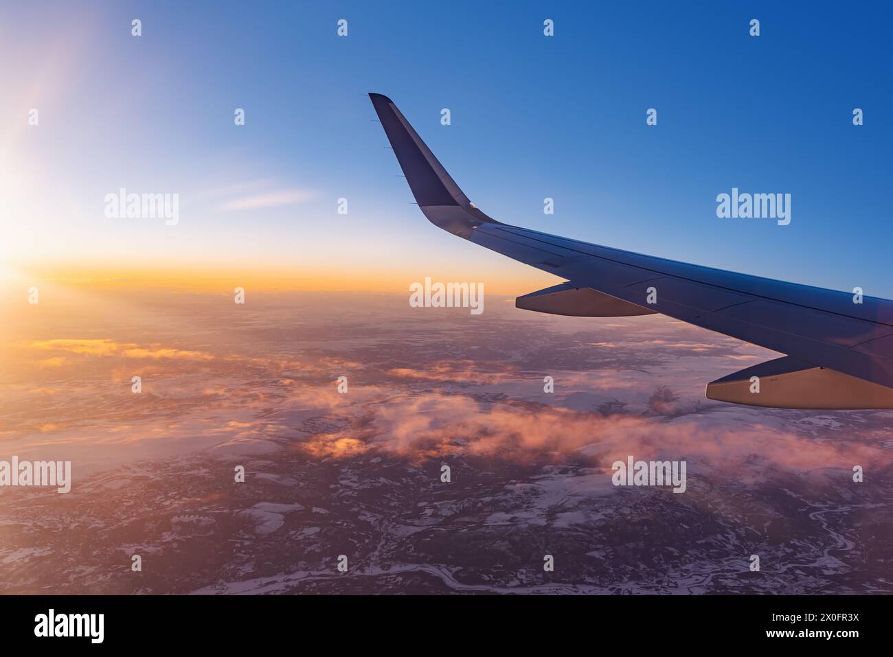 Avion volant bas au-dessus de montagnes enneigées et se préparant à atterrir à l'aéroport, vue depuis la fenêtre de l'avion de la turbine d'aile et de l'horizon Banque D'Images