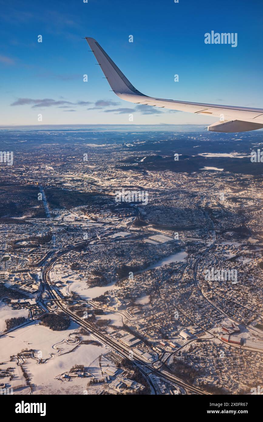 Avion volant bas au-dessus de montagnes enneigées et se préparant à atterrir à l'aéroport, vue depuis la fenêtre de l'avion de la turbine d'aile et de l'horizon Banque D'Images