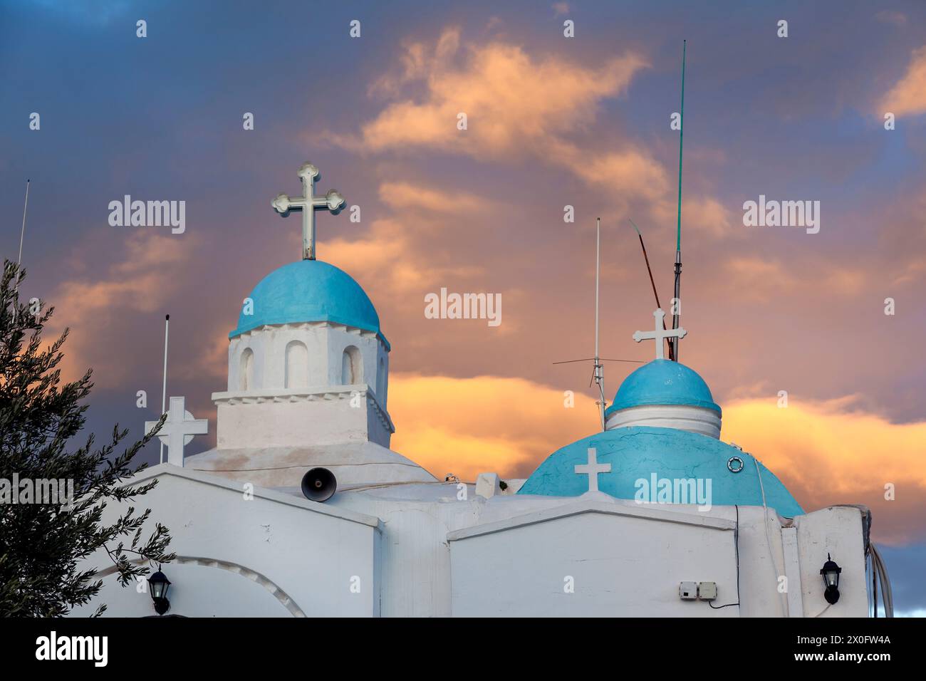La chapelle de Saint Georges (Agios Georgios) au sommet de la colline Lycabette à Athènes, Grèce pendant un coucher de soleil glorieux avec des nuages dorés. Banque D'Images