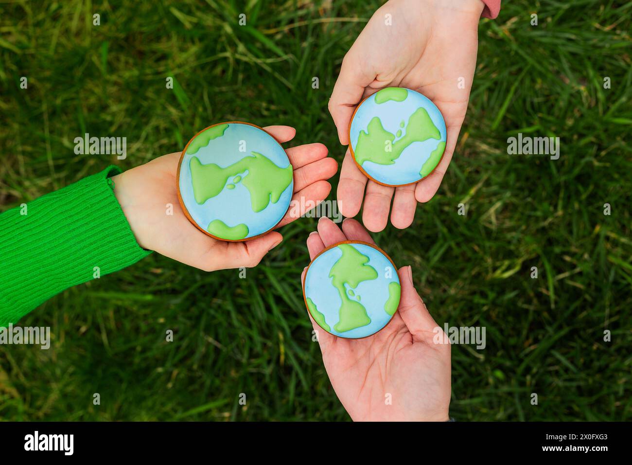 Concept de jour de la Terre. Les mains tiennent le pain d'épices en forme de Terre. Prendre soin de l'environnement. Banque D'Images