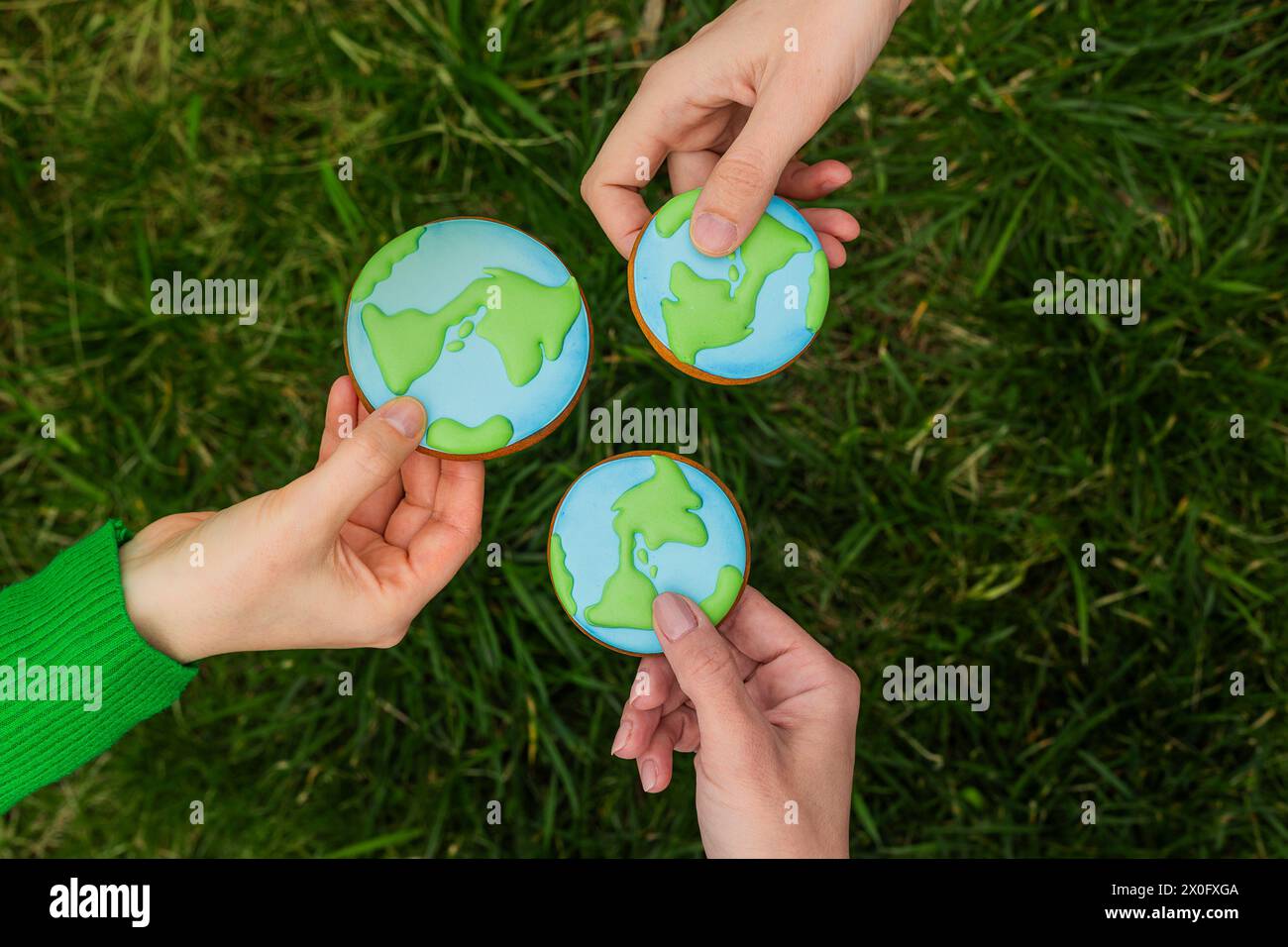 Concept de jour de la Terre. Les mains tiennent le pain d'épices en forme de Terre. Prendre soin de l'environnement. Banque D'Images
