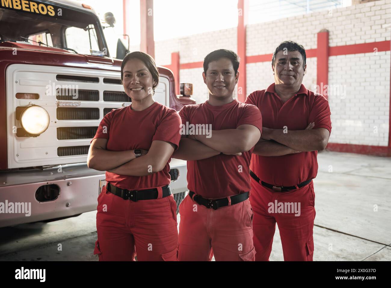 Équipe de pompiers femmes et hommes souriants debout à la caserne de pompiers Banque D'Images