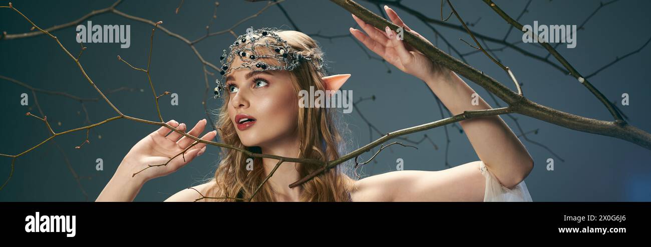 Une jeune femme dans une robe ornée d'une couronne de branches sur sa tête, incarnant l'essence d'une princesse elfe de conte de fées. Banque D'Images
