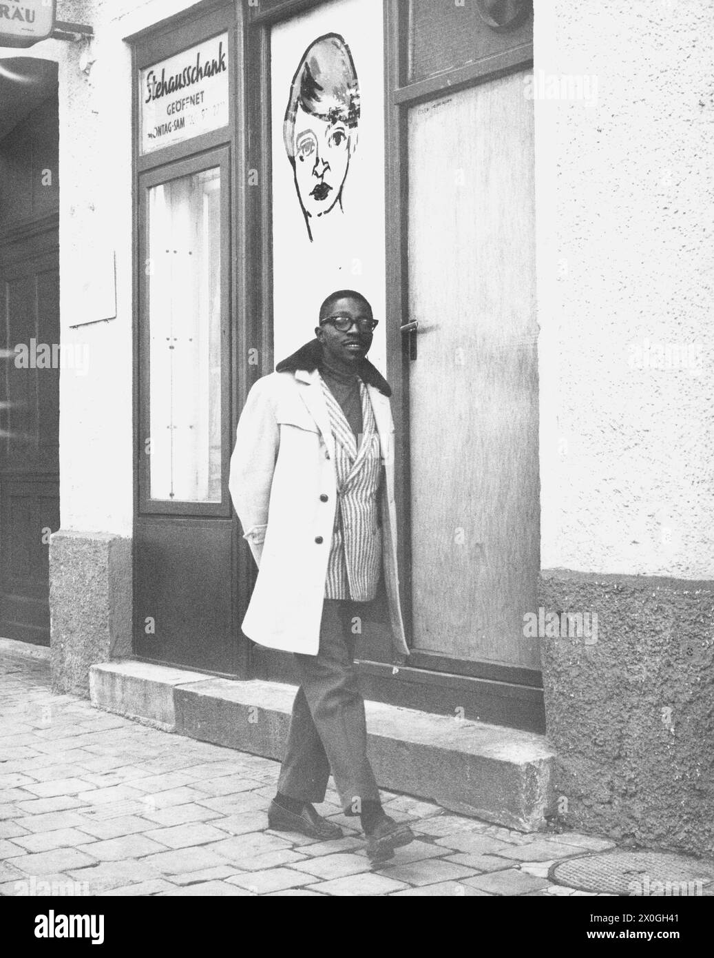 Un homme marche sur un trottoir. En arrière-plan, un bar stehaus.(image non datée) [traduction automatique] Banque D'Images