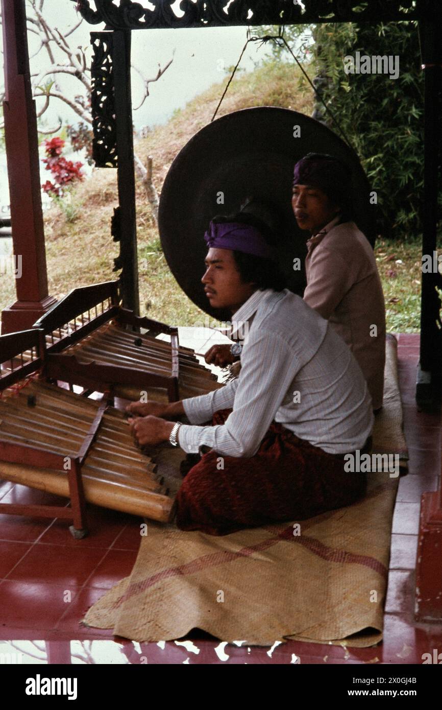 Deux joueurs de xylophone devant un gong sur la terrasse d'un restaurant d'excursion à Kintamani. [traduction automatique] Banque D'Images