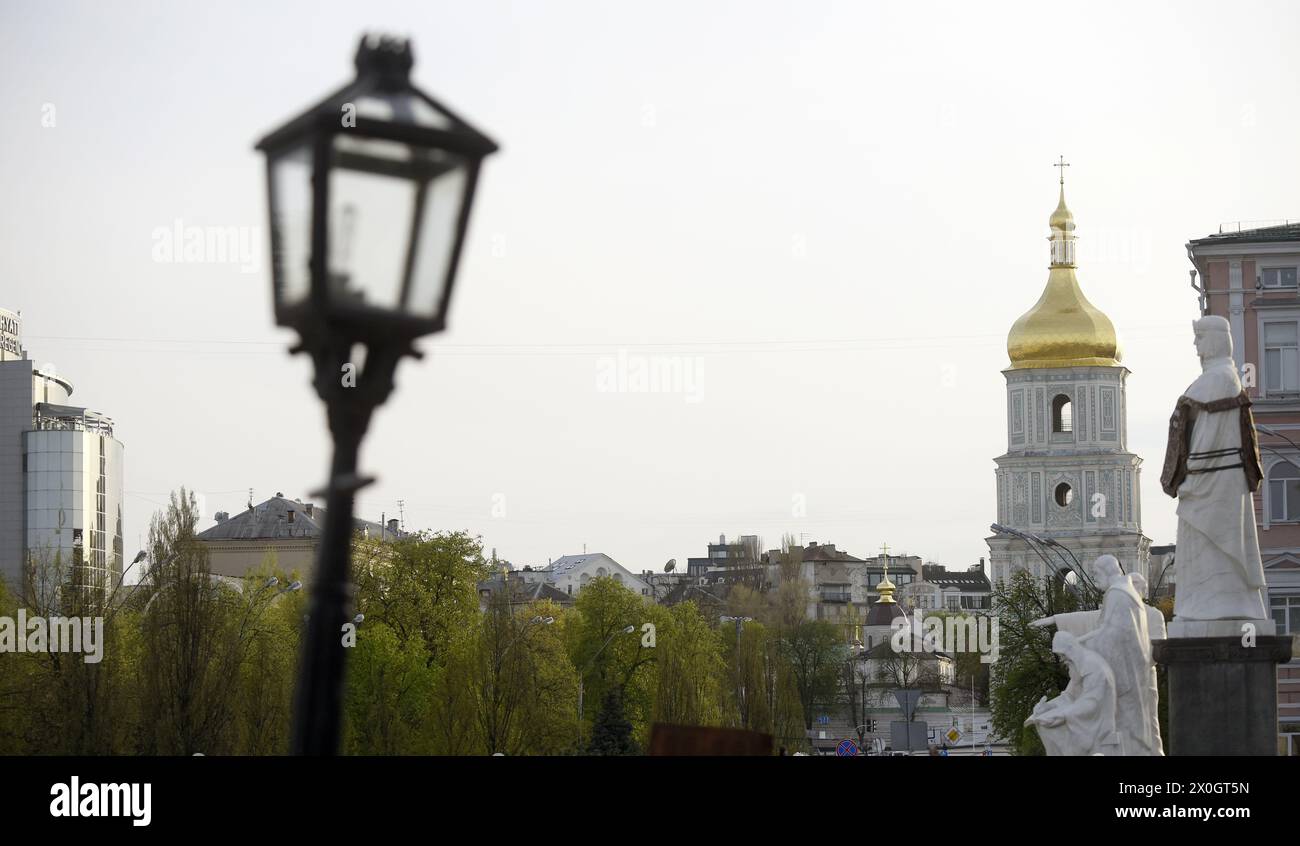 KIEV, UKRAINE - 11 AVRIL 2024 - le monument à la princesse Olga dans le gilet pare-balles et le clocher de la cathédrale Sainte-Sophie sont photographiés à Kiev, capitale de l'Ukraine. Banque D'Images