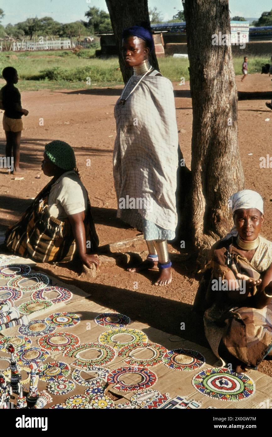 Les femmes avec bagues de cou vendent des perles et des bijoux dans un village de Ndebele en Afrique du Sud. [traduction automatique] Banque D'Images
