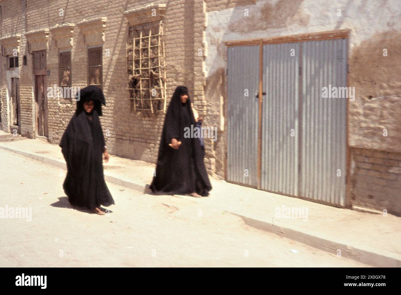 Deux femmes avec hijab et voile devant une façade de maison à Curbela. [traduction automatique] Banque D'Images