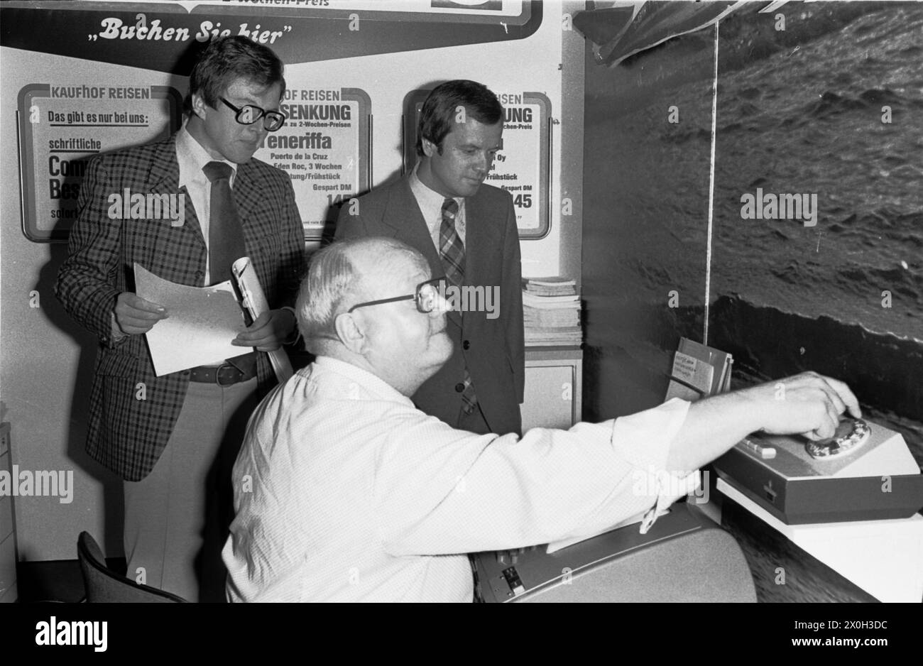 Agence de voyages dans les années 1970, réservation sensationnelle et confirmation de voyage sur ordinateur [traduction automatique] Banque D'Images