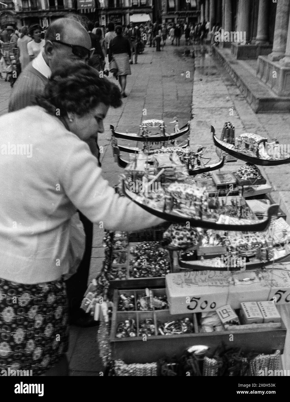 Vendeur avec de petits souvenirs à vendre sur une place à Venise. [traduction automatique] Banque D'Images